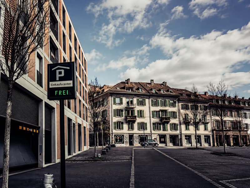 Entrance to a shopping-centre car park with a ‘spaces free’ display on an empty street