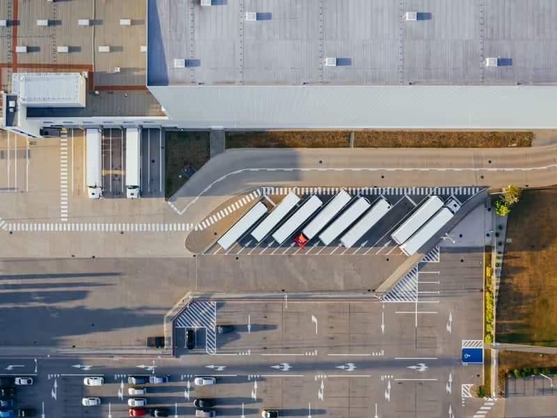 Aerial view of a commercial site with lorries at the loading bays and marked parking areas