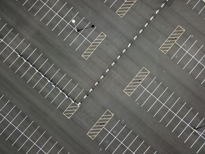 Aerial view of empty diagonal parking bays with white and yellow markings