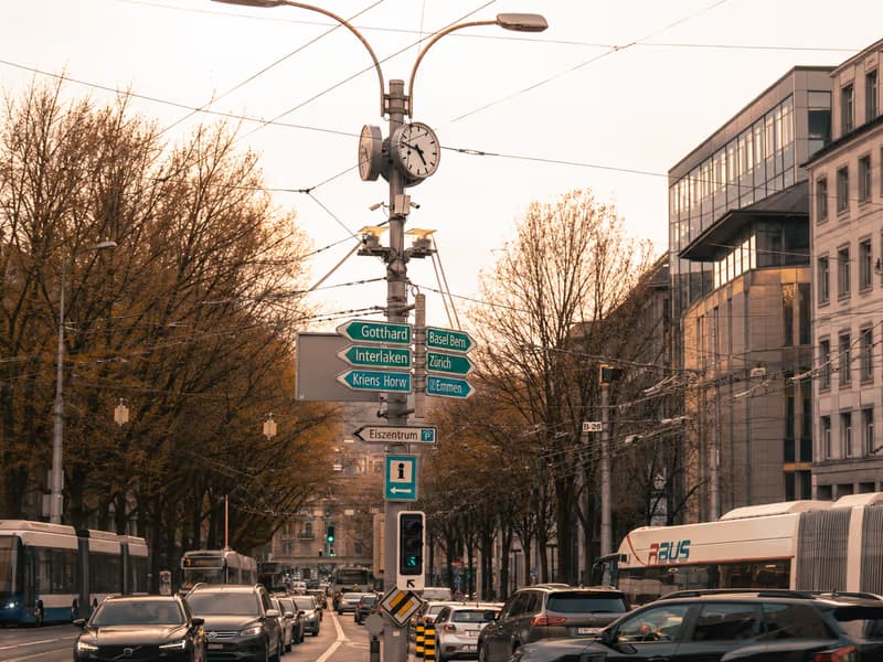 Zurich street with a tram, traffic and direction signs towards Gotthard and Interlaken